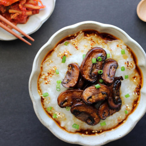 A bowl of instant pot congee topped with pan seared mushrooms.